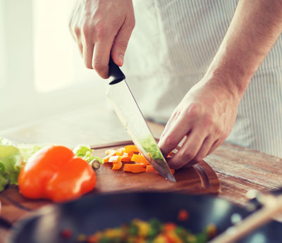 Male Hand Cutting Pepper on Cutting Board